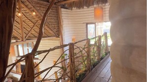 A wooden deck with a thatched roof, potted plants, and a view of the surrounding area. - Solar Kaeté (Santo Amaro do Maranhão)