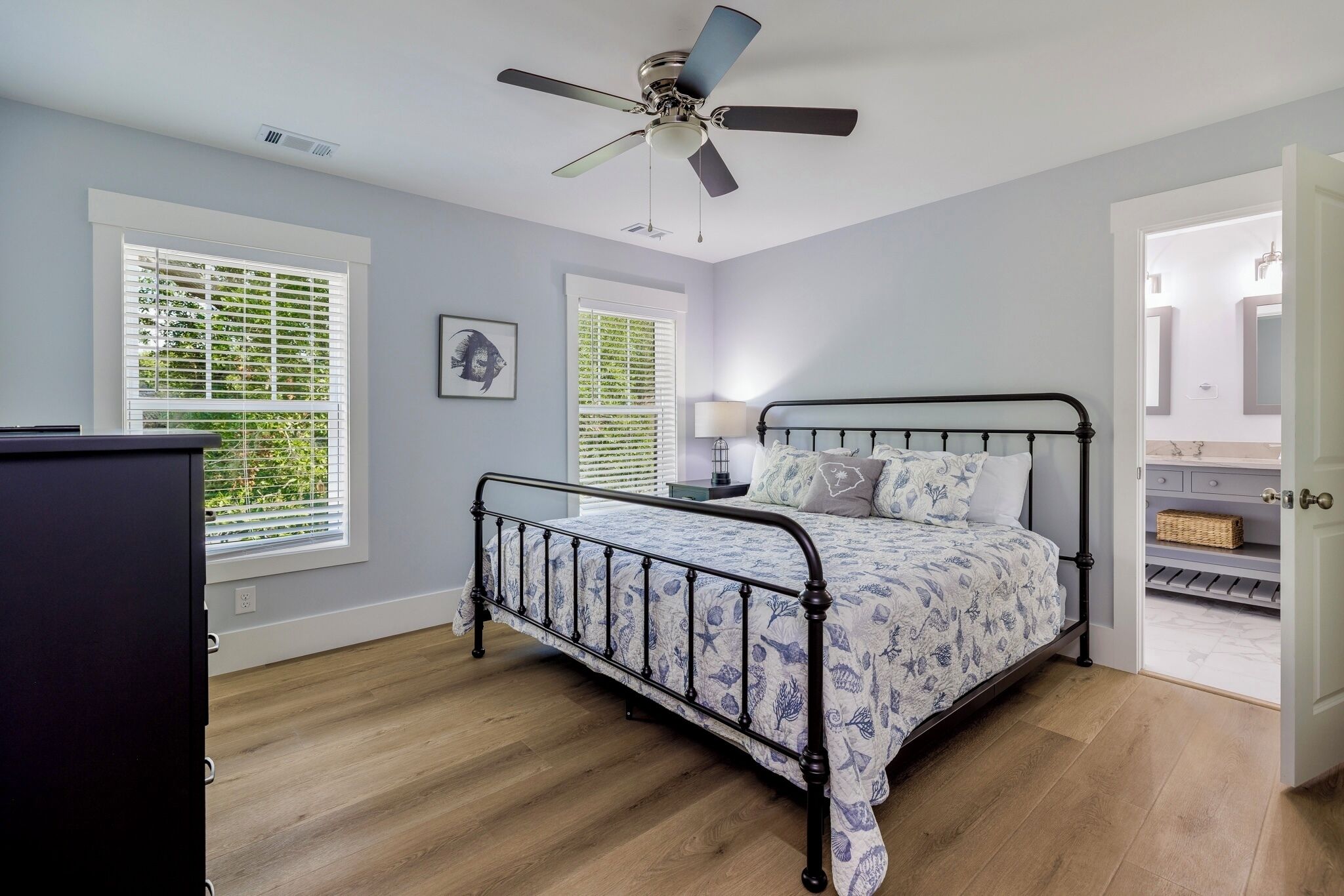 A bedroom with a bed, a ceiling fan, and a window with blinds.