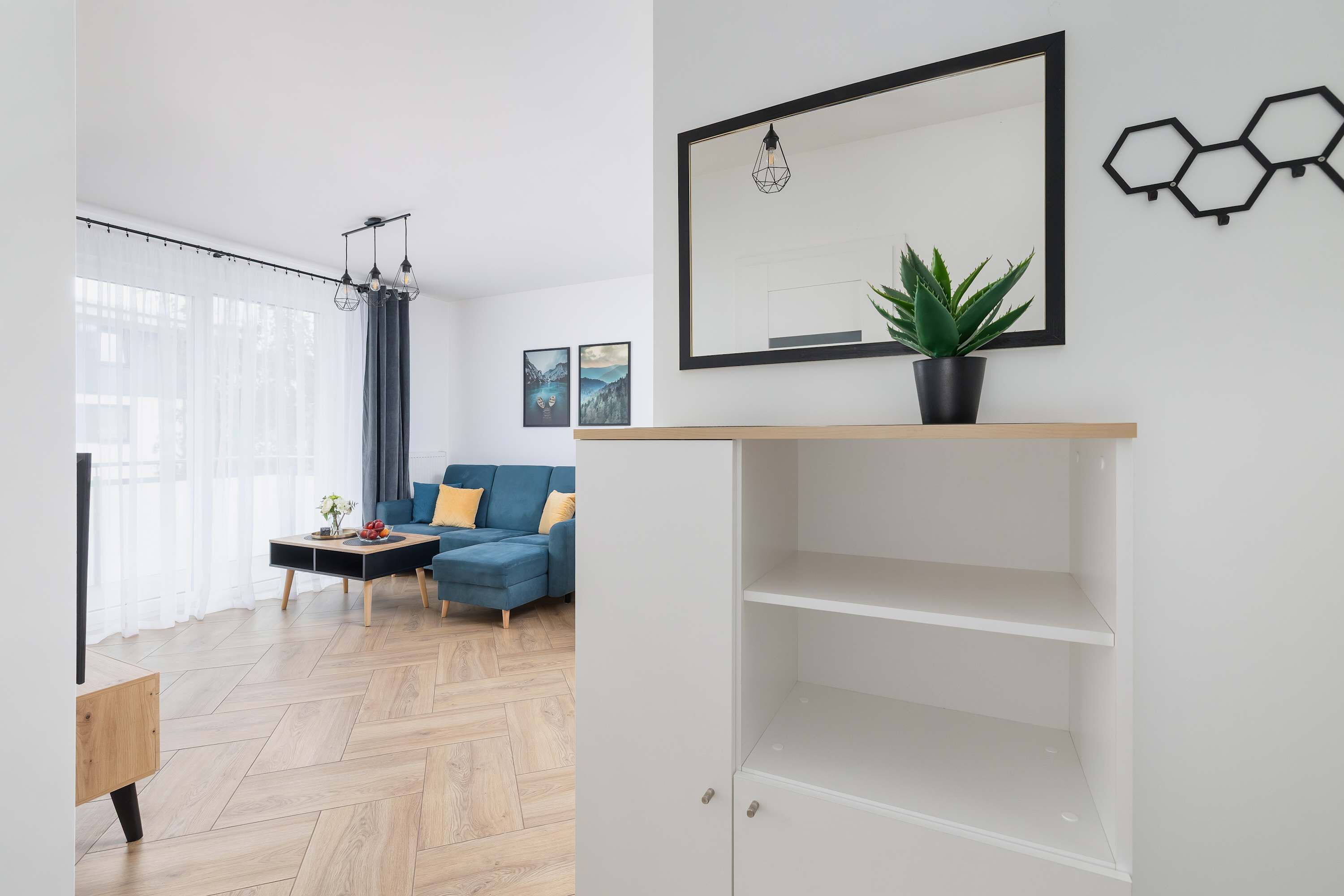 Una sala de estar moderna con un sofá, una mesa de centro y una planta en maceta.