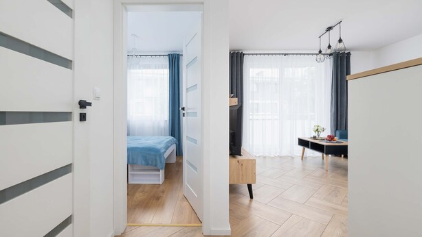 A modern bedroom with a bed, a desk, and a chair.