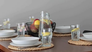 A dining table set with plates, glasses, and a basket of fruit. - Elegant Apartment | 150 m from the Beach, Terrace, Parking (Międzywodzie)