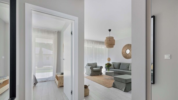 A modern living room with a sofa set, a coffee table, and a hanging light fixture. - Elegant Apartment | 150 m from the Beach, Terrace, Parking (Międzywodzie)