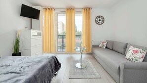 Una sala moderna con una cama, sofá y una mesa de vidrio.