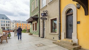 A street with a building labeled "Galeria" and a yellow wall with a black door. - Cozy Apartment in the Heart of the Old Town | Smart TV and Wi-Fi (Warszawa)