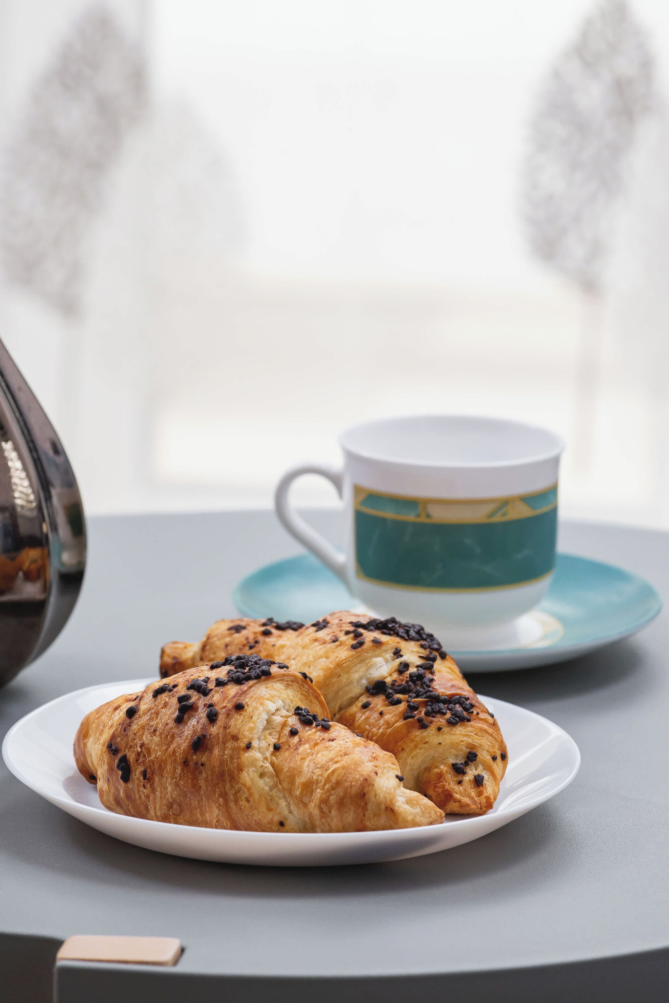 Une assiette avec des croissants et une tasse sur une table.