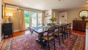 A dining area with a wooden table, chairs, and a patterned rug. - Modern Mountain Retreat w/ Chef’s Kitchen (Manchester)