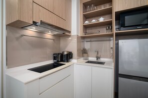 Een moderne keuken met een roestvrijstalen koelkast, een inbouwoven, een magnetron en een koffiezetapparaat.