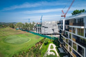 Un edificio moderno en construcción, con un campo de golf al frente.