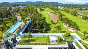 Un hôtel moderne doté d’une piscine sur le toit, d’un parcours de golf et situé au bord d’une rivière.