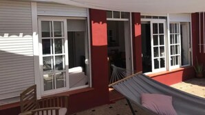 Een kamer met een hangmat, een stoel en een raam met uitzicht op het interieur.