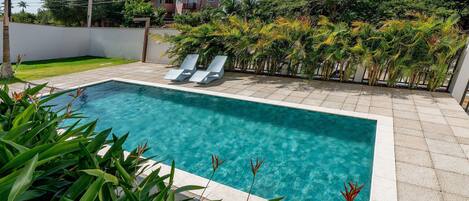 Una piscina techada, sillones reclinables de piscina