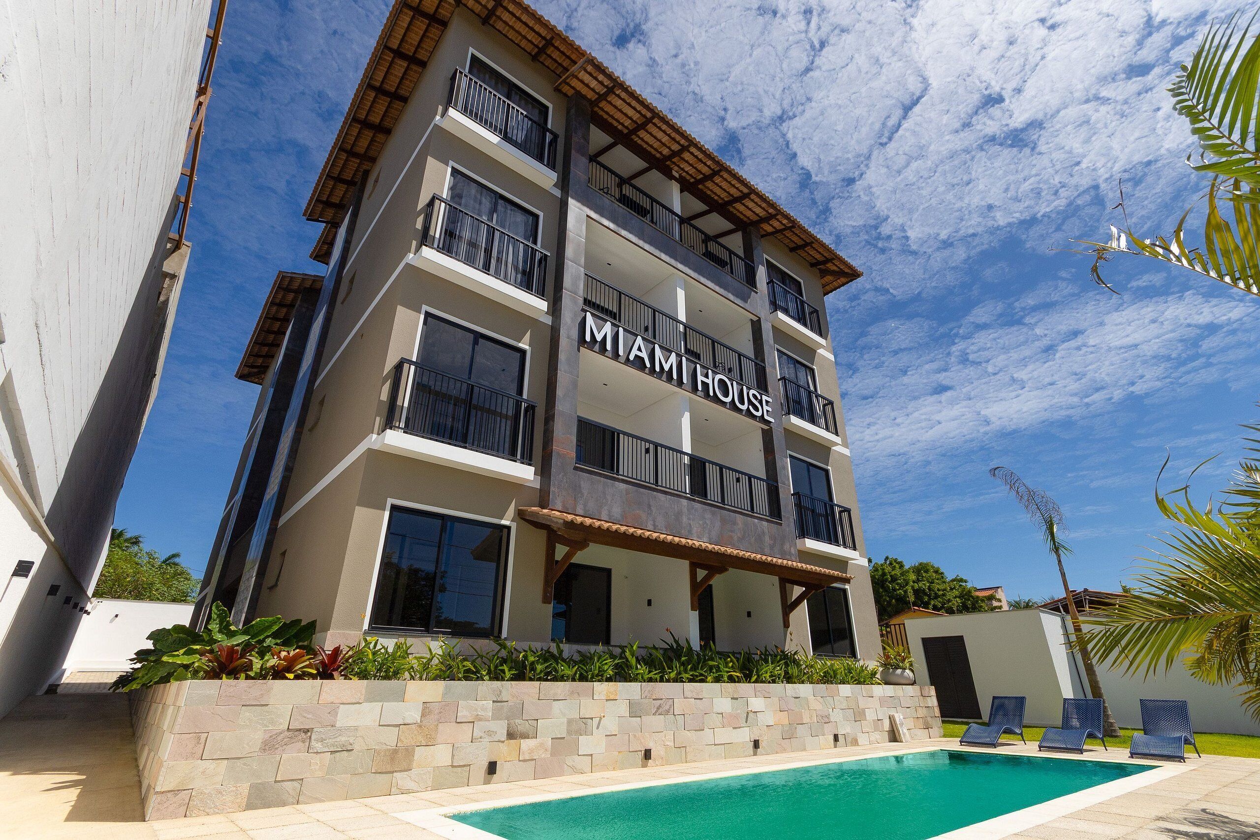 A multi-story building with balconies and a pool area.