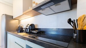 A modern kitchen with a built-in stove, a coffee maker, and a kettle. - Miami House Cumbuco by Carpediem (Caucaia)