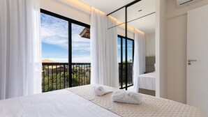 A hotel room with a large bed, a balcony with a view, and a modern design. - Miami House Cumbuco by Carpediem (Caucaia)