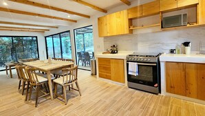 A modern kitchen with wooden cabinets, a built-in microwave, and a stainless steel oven.