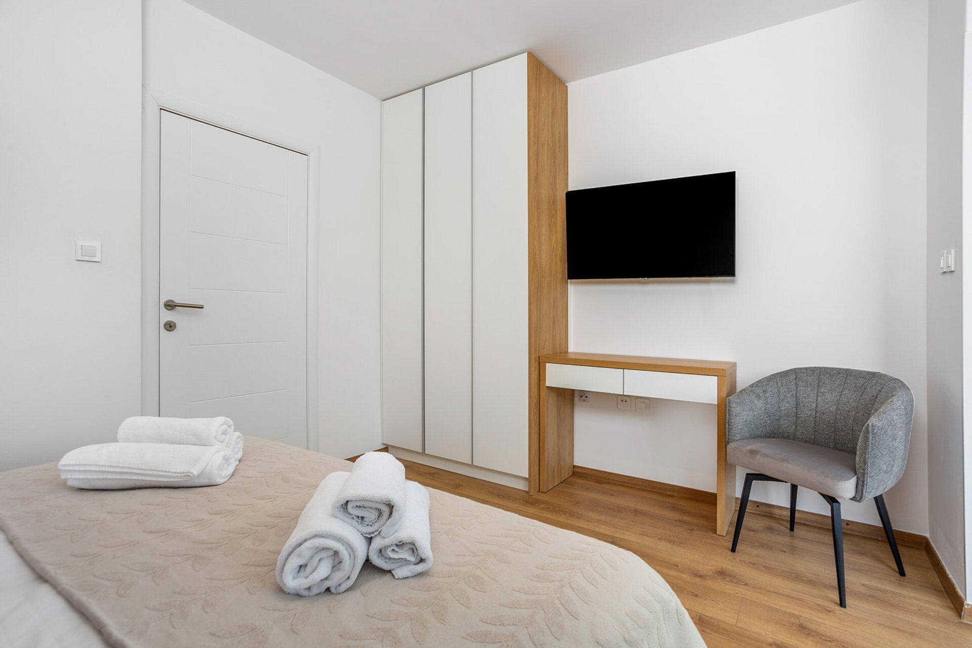 Ein Schlafzimmer mit Bett, Schreibtisch, Stuhl und Fernseher.
