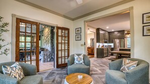 A spacious living area with a stone fireplace, a dining table, and comfortable seating. - Ultimate Creek Retreat- private 250 ft waterfront - Hot Tub, Sauna, Game Room (Epworth)