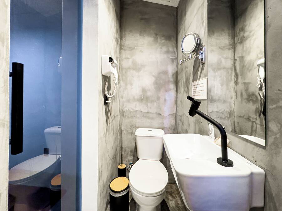 A compact bathroom with a toilet, sink, and mirror.