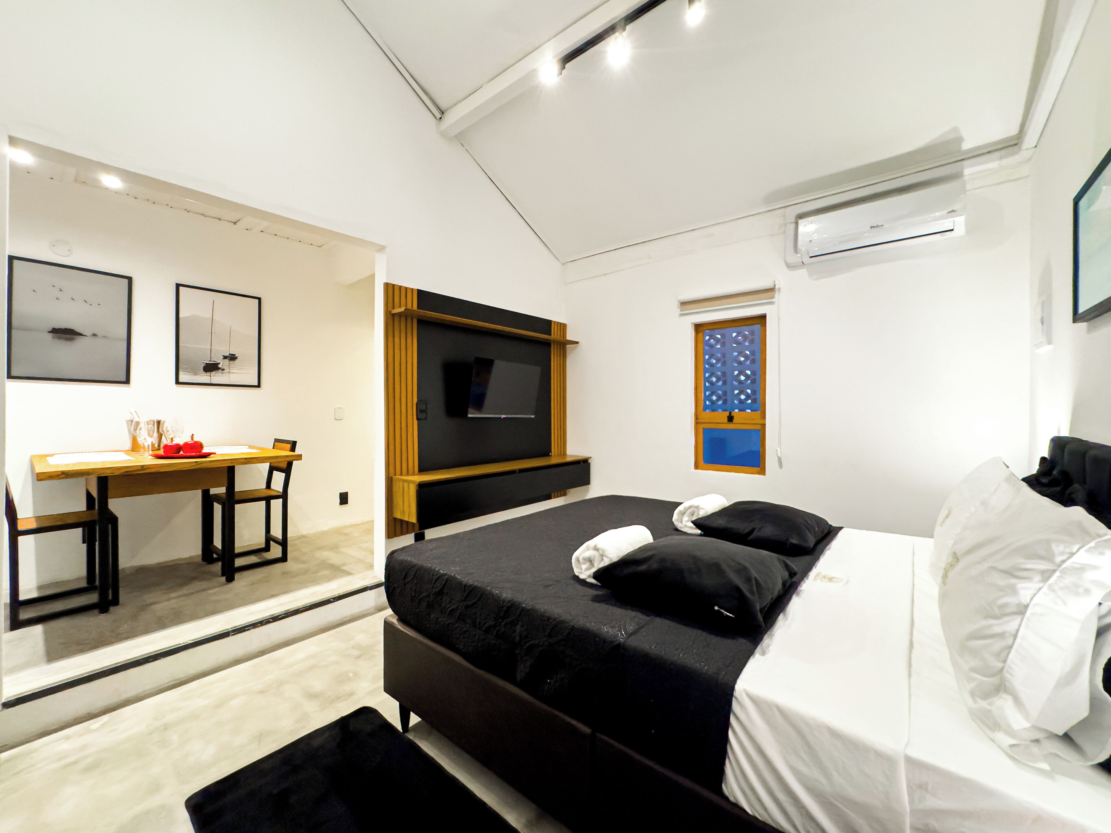 Una habitación de hotel moderna con cama, escritorio y televisión.