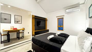 Una habitación de hotel moderna con cama, escritorio y televisión.