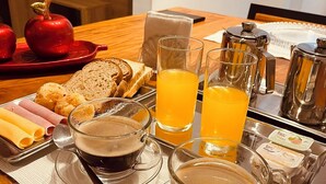 A breakfast tray with toast, apples, ice cream, juice, coffee, and tea. - Pousada Praia do Carioca (Búzios)
