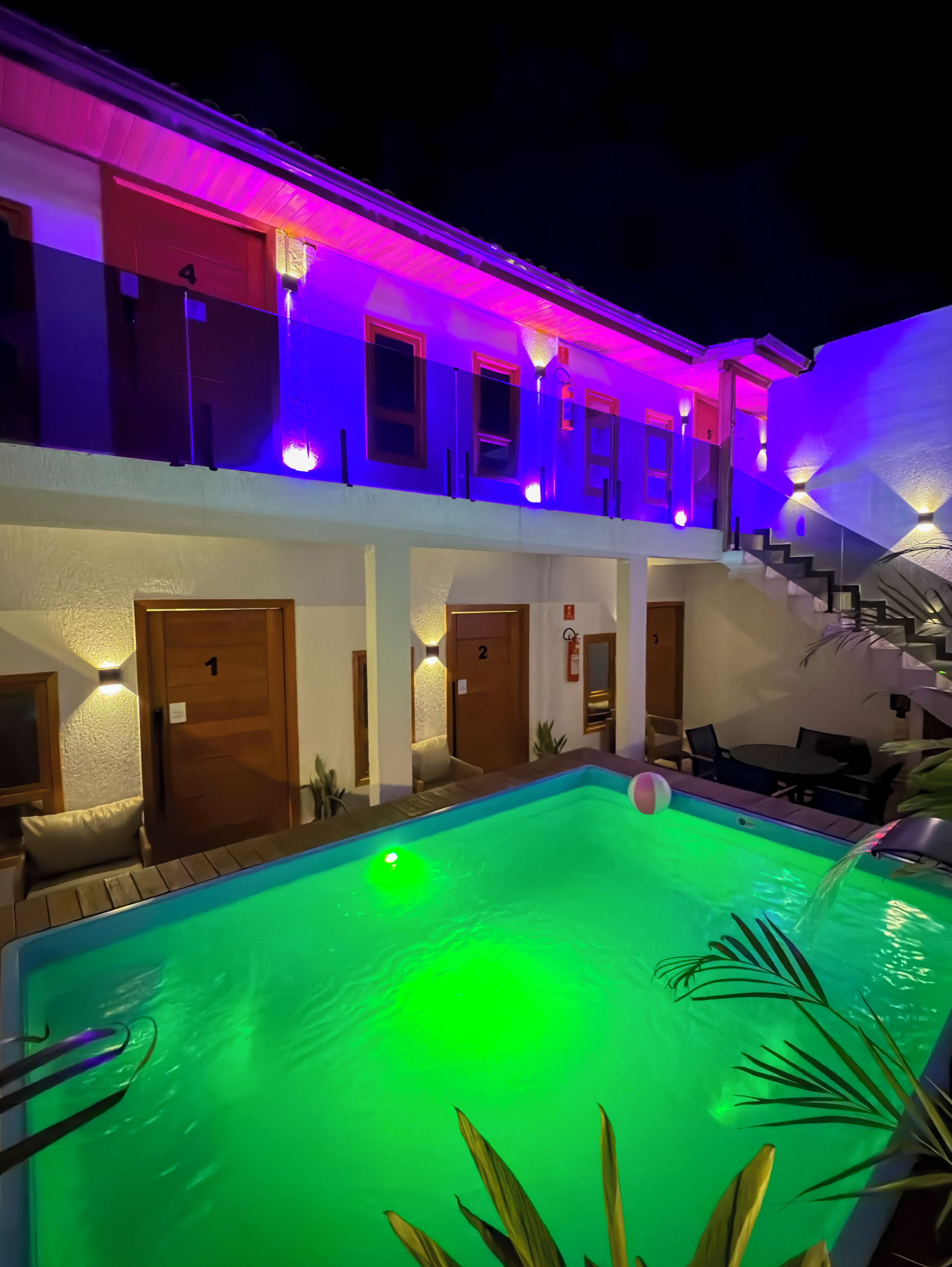 A multi-story hotel with a swimming pool, each floor with a door numbered 1 to 4, and a staircase leading to the upper floors.