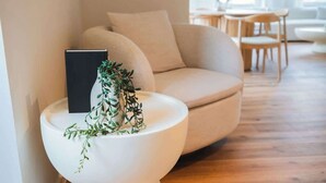 A modern living room with a white toilet, a beige sofa, and a small wooden table.
