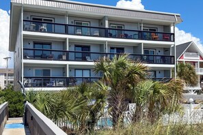 Un hôtel à plusieurs étages doté de balcons, d’un espace piscine et offrant une vue sur la plage.
