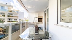 A balcony with a glass table and a potted plant. - Apart w/ Barbecue in Condominium With Pool Bri0102 (Florianópolis)
