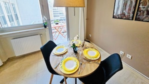 Un comedor con una mesa dispuesta para cuatro, un ventanal y vistas al exterior.