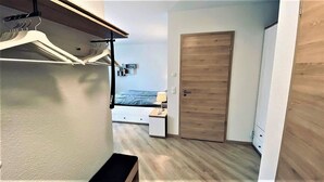 A compact bedroom with a bed, bedside table, and a wardrobe. - Warnowperle (Rostock)