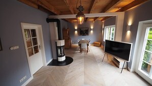 Un salon moderne avec une cheminée, un coin repas et un téléviseur.