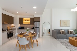 Una cocina moderna con comedor, un sofá gris y un espacio de sala minimalista.