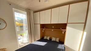 Ein Schlafzimmer mit einem Bett, einem hölzernen Kopfteil und einem eingebauten Kleiderschrank.