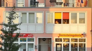 Un immeuble de deux étages doté de balcons et d’un commerce situé au rez-de-chaussée.