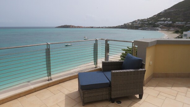 A balcony with a view of a beach and ocean. - Charming 2bdrm/2bath beachfront PH Condo WiFi, AC, TV, beach lounges included (Philipsburg)