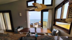 A kitchen with a granite countertop, a sink, and a dining area with a table and chairs. - Charming 2bdrm/2bath beachfront PH Condo WiFi, AC, TV, beach lounges included (Philipsburg)