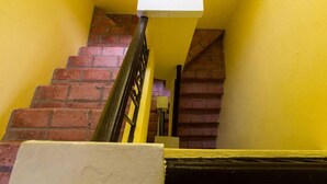 Una escalera con paredes amarillas y escalones de ladrillo rojo.