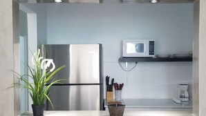 A modern kitchen with a built-in refrigerator, microwave, and coffee maker. - Private Pool Piscina Privada by CasaSaffra (San Juan)