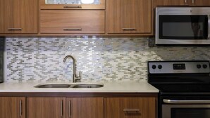 A kitchen with wooden cabinets, a stainless steel microwave, and a tiled backsplash. - 5 Bedroom with Private Pool NEXT TO BEACH (San Juan)