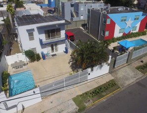 A residential area with a modern house, a swimming pool, and a building with a star mural. - This listing is for two (2) spacious  homes, next to each other (San Juan)
