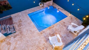 A rooftop pool with two white lounge chairs and string lights. - Extra Large Spacious Beach House with Solar Panels and 800 gallon cistern (San Juan)