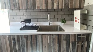 A modern kitchen with a central island, a sink, and wooden cabinetry.
