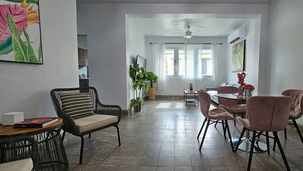 Un amplio salón con una mesa de comedor y sillas, un sofá y una mesa de centro.