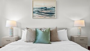 A neatly made bed with a white comforter, two bedside tables with lamps, and a framed picture above the bed. - Tropical San Juan Life with Pool (San Juan)
