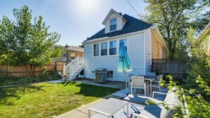 A backyard with a patio area, outdoor furniture, a grill, and a staircase leading to the house. - Logan Square Urban Oasis: 2 Mi to Local Hotspots! (Chicago)
