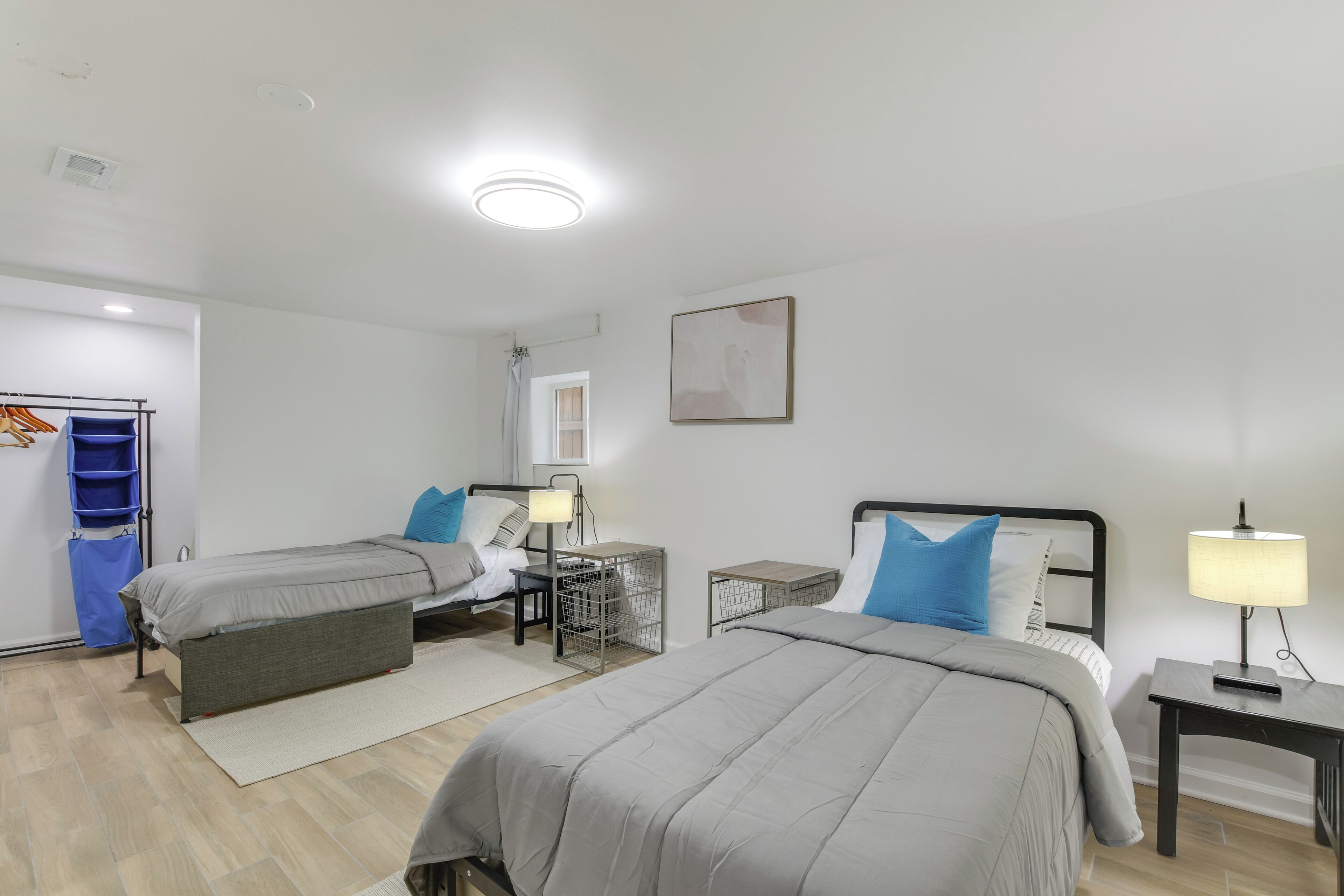 Habitación de hotel con dos camas, un escritorio, una silla, un armario y baño.
