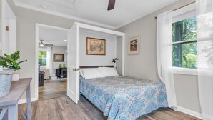 A bedroom with a bed, a ceiling fan, and a window with curtains. - Cozy Spot - Perfect for Long Stays - Walk Downtown (Spartanburg)