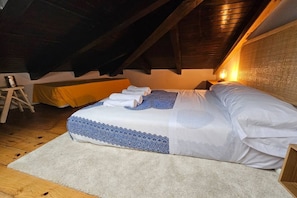 A bedroom with a bed, a wooden ladder, and a nightstand.