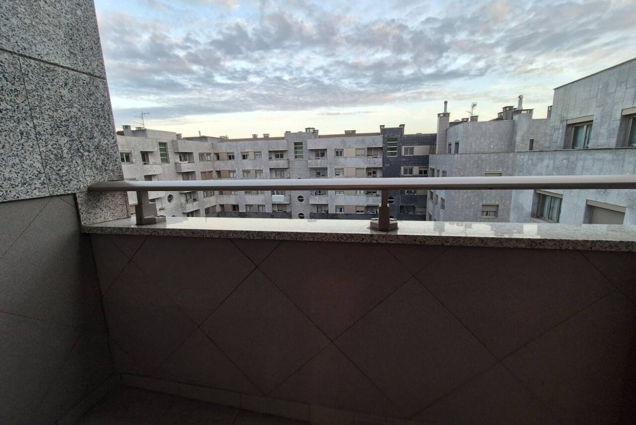 Een balkon met uitzicht op een wooncomplex.